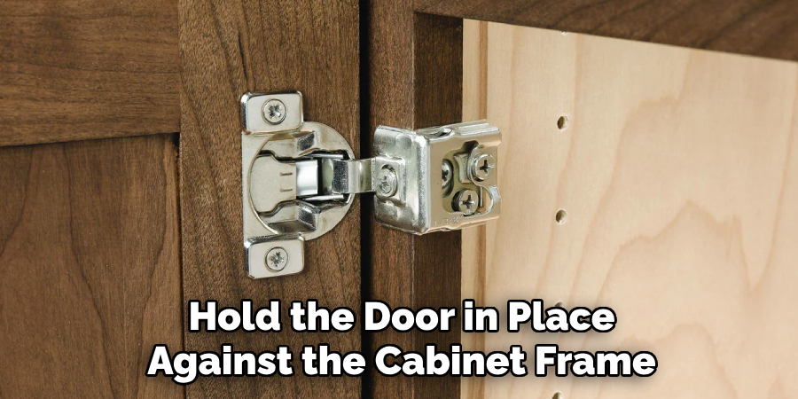 Hold the Door in Place 
Against the Cabinet Frame